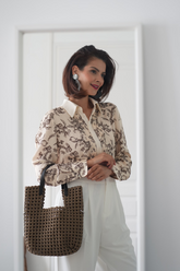 a lady wears a floral printed shirt with floral prints